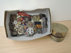 A collection of Military Badges including Plastic Economy Issue, Kings Own etc along with a Brass