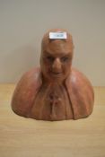 A well modelled terracotta/earthernware bust of a Catholic clergyman, with patinated finish.