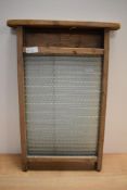 A vintage glass and wood washboard.