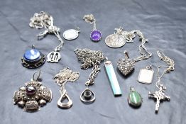 A selection of silver and white metal pendants, several stamped silver including St Christopher, WI,