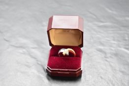 A white and yellow metal serpent style ring of plain form having clear stones (not diamonds) set