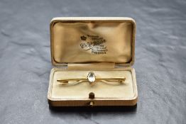 A yellow metal bar brooch stamped 15ct having central aqua marine in claw mount, approx 3.4g