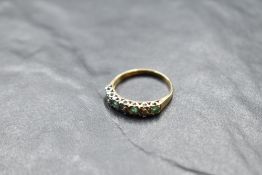 An emerald and diamond half eternity ring having an illusionary setting on a 9ct gold loop, size R &