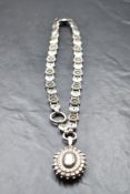A Victorian silver locket of oval form having moulded and engraved decoration on a white metal fancy