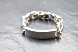 A gent's 1970's silver curb link identity bracelet of heavy form having plain panel and bark