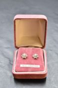 A pair of white metal stud earrings having central diamond in floral mounts, no marks, approx 1.3g