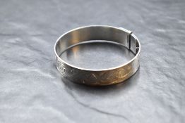 A silver belt style bangle having engraved decoration