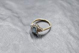 A blue topaz and diamond cluster flanked by a further trio of diamonds to each side, total approx