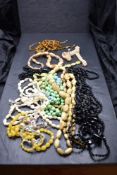 A selection of vintage strings of beads including mourning, mother of pearl, horn, crystal etc