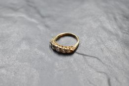 A five stone graduated diamond ring, total approx 1ct, having diamond chip spacers (3 missing) in