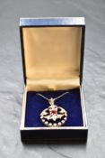 An Edwardian white metal hinged pendant having central cushion cut ruby within a diamond set mount