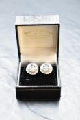 A pair of white metal and diamond earrings, of circular form with an arrangement of diamond