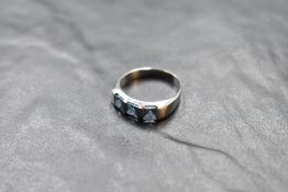 A three stone square cut blue topaz ring having bar settings on a white metal loop stamped C0-074,