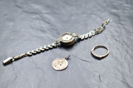 A half eternity ring having four blue topaz style stones interspersed by small diamond chips on a