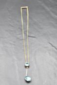An early 20th Century blue topaz pendant with knife blade drop to further stone on a fixed yellow