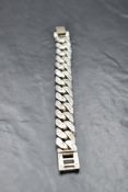 A gent's 1970's silver curb link bracelet of heavy form having engraving to the links, approx