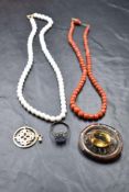 A short string of facet cut coral beads, a silver dress ring, a Celtic white metal oval brooch