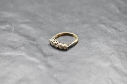 A five stone graduated diamond ring, total approx 0.5ct in a claw set mount on a yellow metal loop
