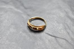 A seven stone garnet and cubic zirconia band ring having cut detail to mount and a 9ct gold loop,