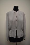A pale blue semi sheer blouse, having tucks to front and self covered buttons and long sleeves