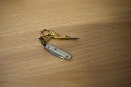 A miniature pair of gold tone sewing scissors in the form of a stork, with boned handled knife