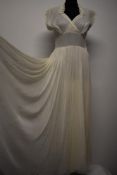 A cream tulle and taffeta evening dress, having lace collar with rhinestone accents, cross over bust