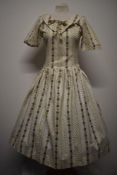 A 1950s textured floral cotton day dress, having statement collar with bow, longline bodice and full
