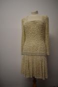 A 1980s does 1920s dress, heavily beaded throughout with long sleeves and dropped waist.