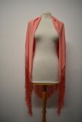 A sillk blend shawl in rose pink, having deep silk fringijng to edges.
