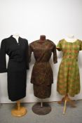 A trio of 1950s to 60s dresses, including autumnal toned dress with layered skirt and black wool