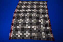 A wonderful Welsh blanket in red, white, black, green and red colour way, with fringing to two