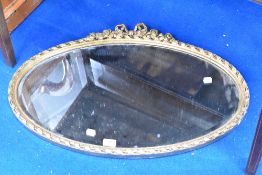 An oval wall mirror having bow decoration
