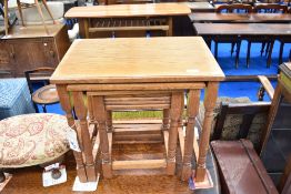 A vintage nest of three golden oak tables