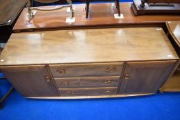 An Ercol sideboard having three central drawers flanked by cupboards