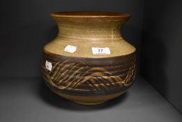 A heavy Studio pottery vase of squat form, having brown glaze with swirled design to centre.