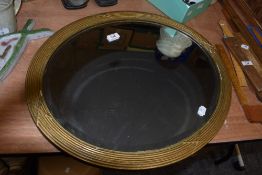 An early 20th century bevelled glass mirror of oval form, having gilt moulder plaster frame.