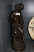 A bronze effect figurine, depicting classically styled semi nude maiden with glass and bottle.