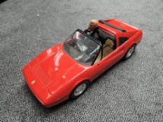 A 1986 Mattel Inc France Barbie Ferrari 328GTS with a 1991 Mattel Ken Doll wearing traditional black
