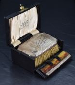 A cased George V silver mounted clothes brush and comb, the clothes brush of canted rectangular