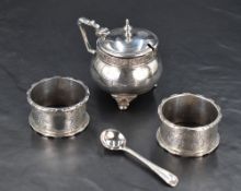 A George V silver mustard pot, of lidded and compressed spherical form with band of foliate