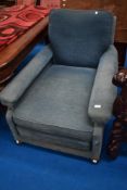 An antique easy chair in the Howard style , of deep proportions