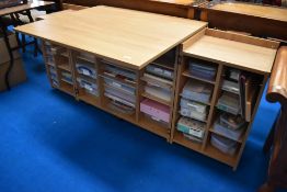 A modern beech laminate work or crafting table/desk having fold out storage to doors and under,