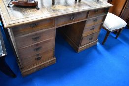 A Victorian oak pedestal desk having aesthetic style handles, width approx. 135cm