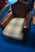 An early 20th Century leather armchair having embossed detail to back and modern tweed style seat