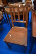 An Arts and Crafts style solid seat hall or dining chair in golden oak