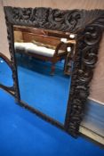 A 19th Century wall mirror having oak foliate frame, approx. 111 x 89cm