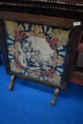 A vintage oak framed firescreen with woolwork castle inset