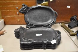 A group of four interesting cast iron steak grill plates, of bull or cow design, each measuring 30cm