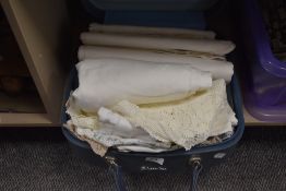 A vintage Sheerline case contain laced and worked table cloths and other soft goods