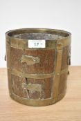 An 19th century Indian rice measure, having brass bands to wood and brass looped handles with